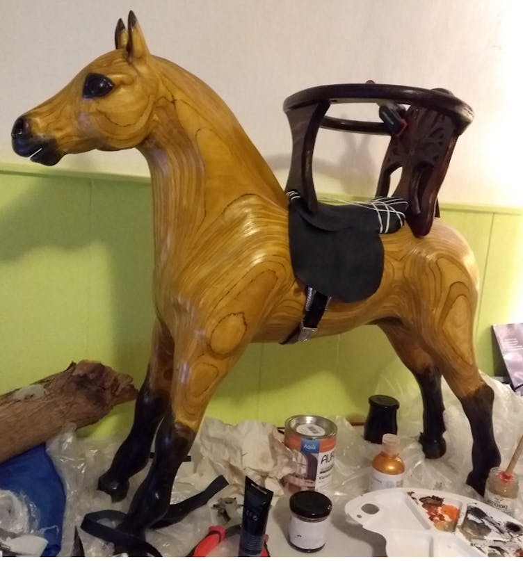 Vanerista rakennettu keinuhevonen syöttötuolilla Vanerista rakennettu keinuhevonen syöttötuolilla